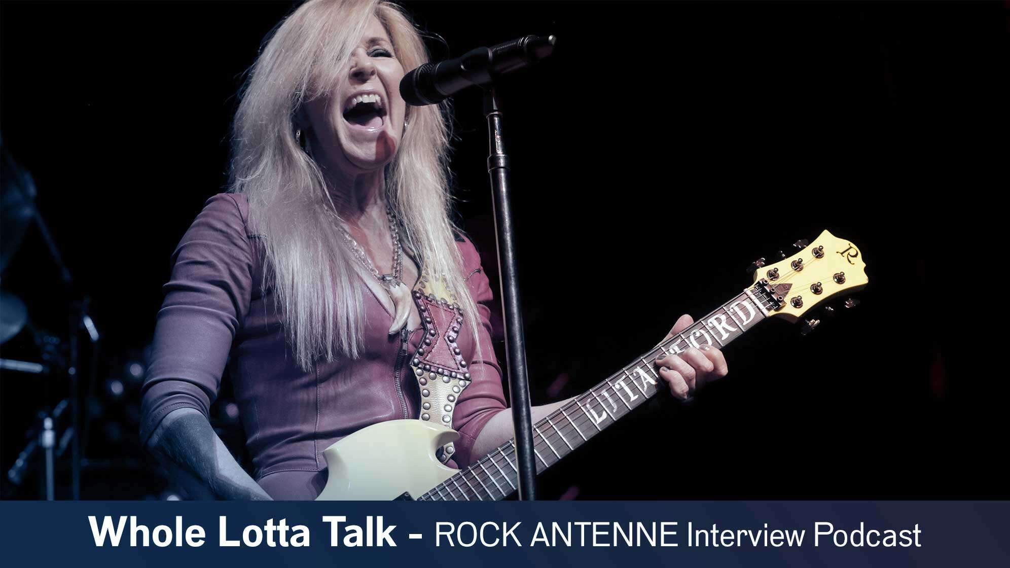 Bild von Lita Ford am Mikrofon und an der Gitarre