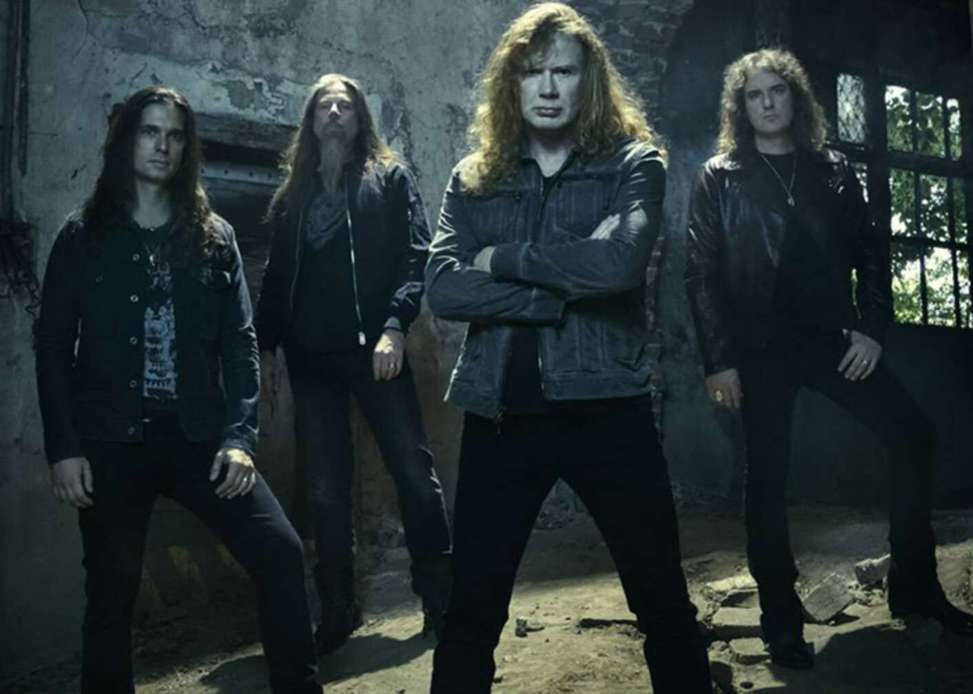 Die Band Megadeth steht in einer dunklen Halle und schaut ernst