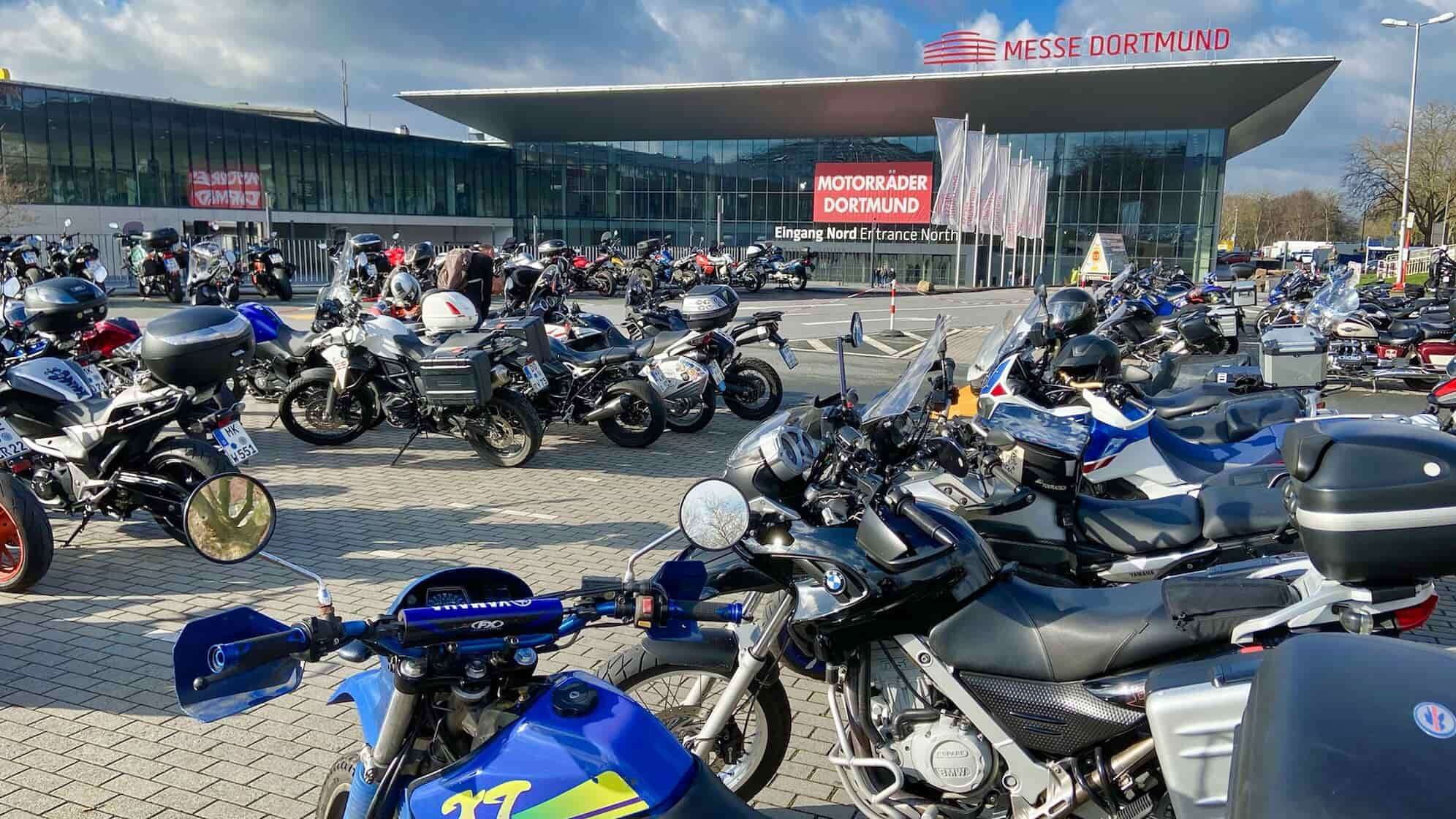 Foto vom Haupteingang der Motorradmesse Motorräder Dortmund mit zahlreichen geparkten Motorrädern verschiedener Marken