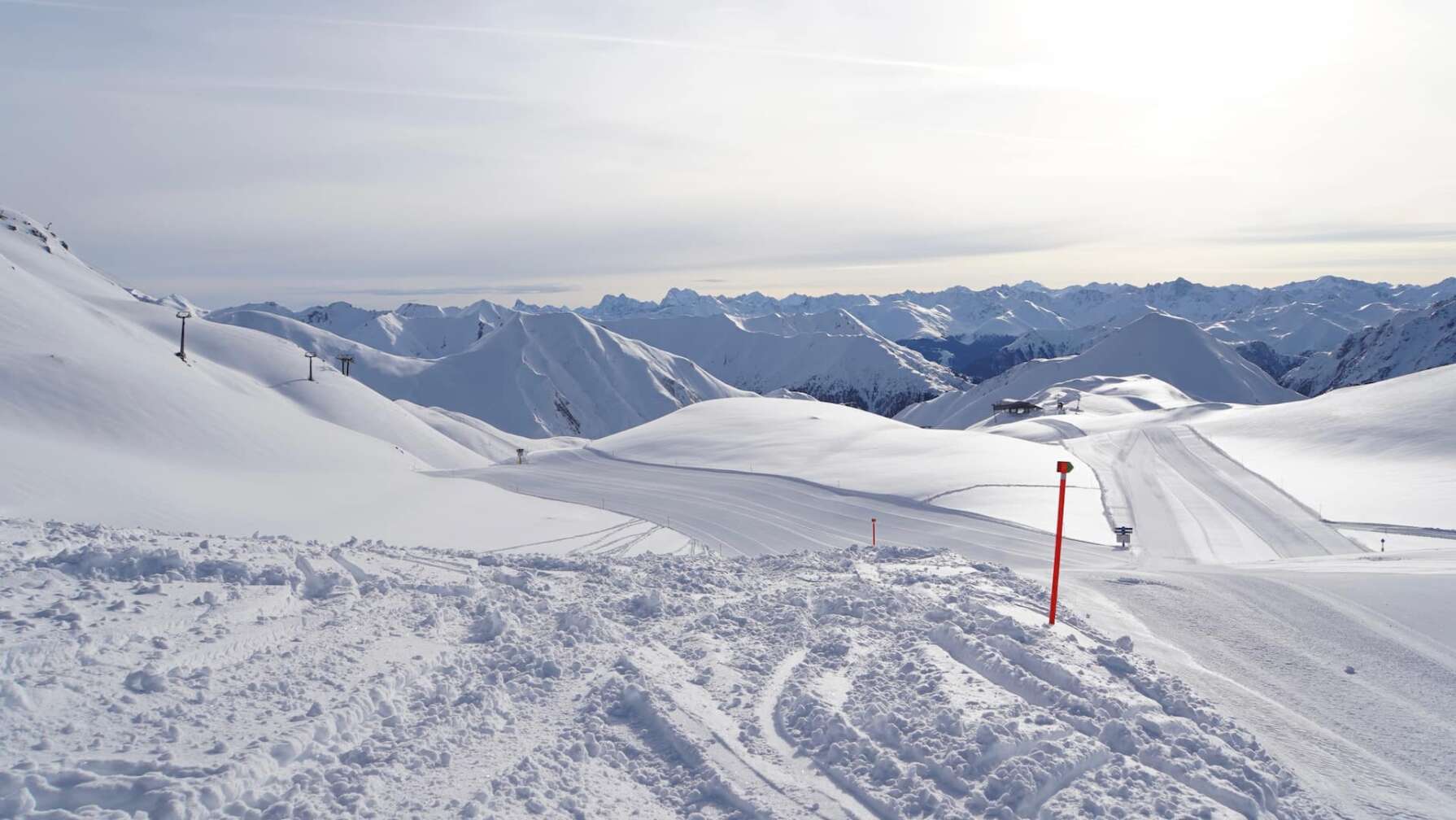 Foto einer schneebedeckten Piste inmitten des hochalpinen Panoramas der Silvretta Arena in Samnaun/Ischgl