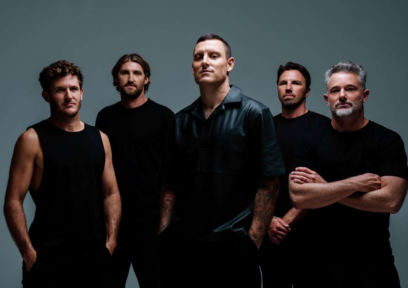 Die Bandmitglieder von Parkway Drive vor einem grauen Hintergrund